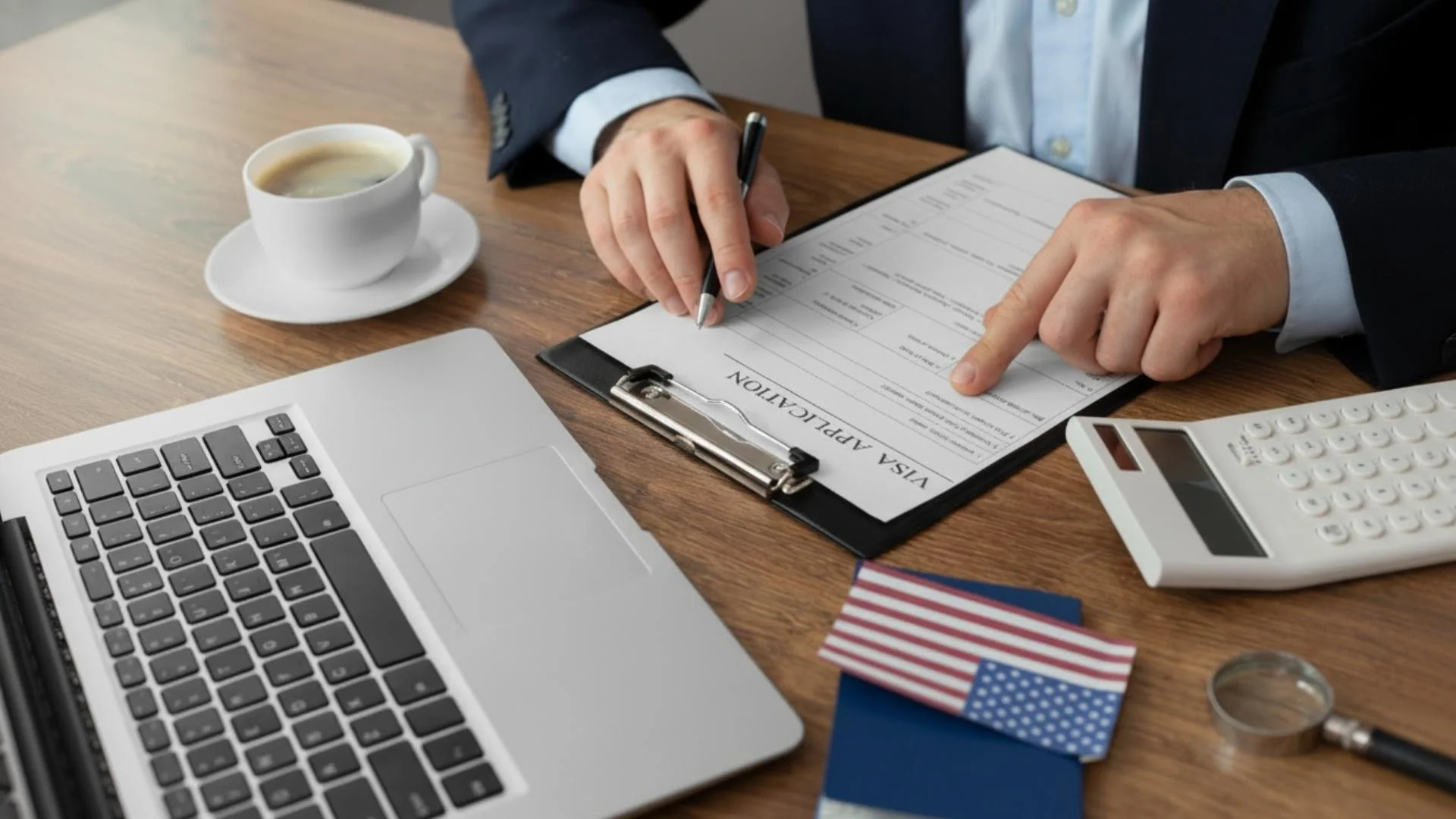 USA Business Visa application form with passport laptop and documents on desk
